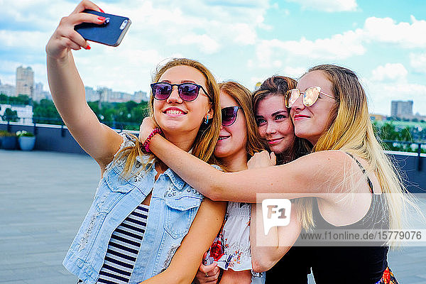 Friends taking selfie with smartphone