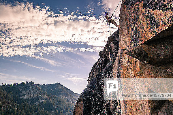 Young male rock climber on rock face High Sierras California USA
