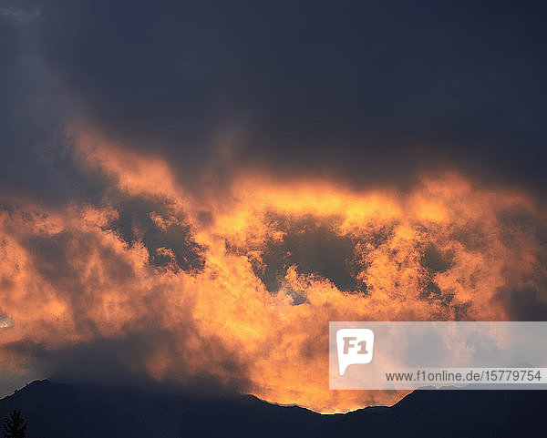 Orangefarbener Sonnenuntergang über den Bergen