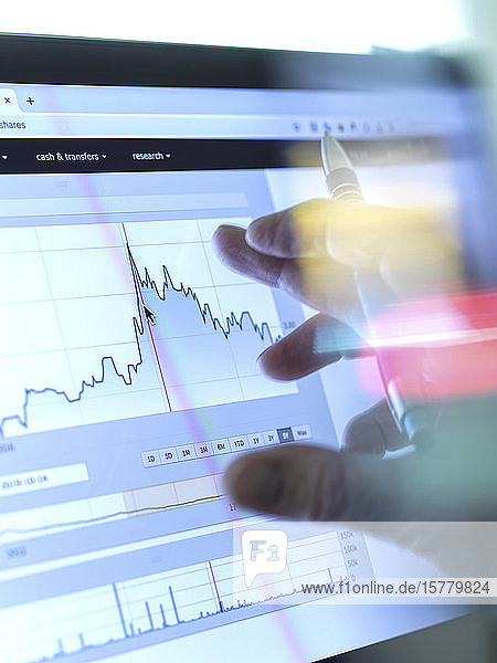 Stock broker analyzing the performance of a company stock on the internet.