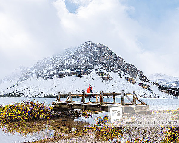 Wanderer überquert im Herbst die Brücke über den Bach  Bow Lake  Kanadische Rockies  Alberta  Kanada