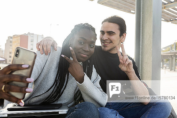 Glückliches junges Paar beim Selbsteinstieg an der Straßenbahnhaltestelle
