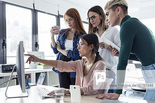 Fünf Geschäftsfrauen benutzen einen PC in einem Büro