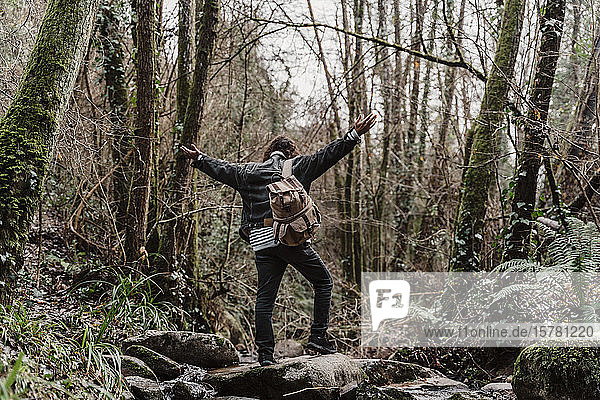 junger Mann mit Rucksack  Dampfdurchquerung im Wald