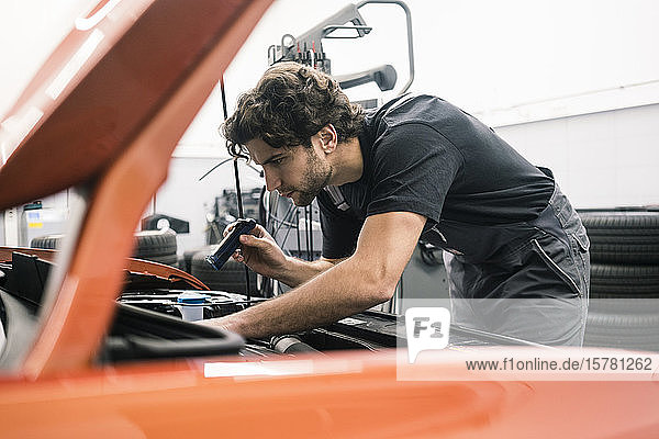 Automechaniker in einer Werkstatt bei der Arbeit am Auto