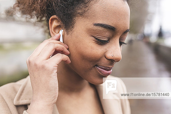 Portrait of smiling young woman with earbuds