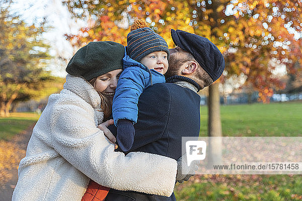Glückliches  liebevolles Paar mit kleinem Sohn im Park