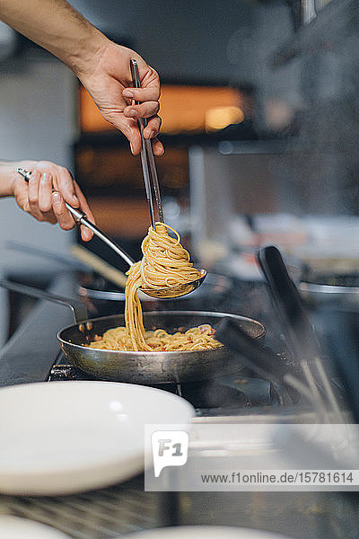 Chefkoch bereitet ein Nudelgericht in der traditionellen italienischen Restaurantküche zu