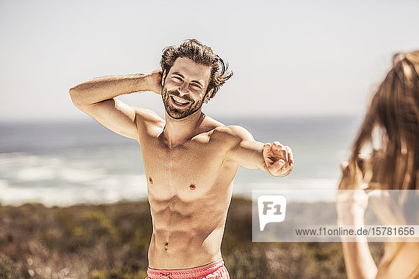 Porträt eines glücklichen jungen Mannes an der Küste