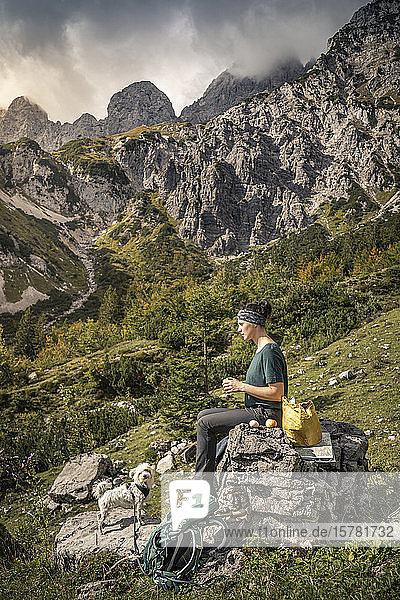 Woman with dog on a hiking trip at Wilder Kaiser having a break  Kaiser mountains  Tyrol  Austria