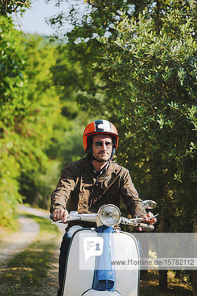 Porträt eines Mannes auf einem Oldtimer-Motorroller  Toskana  Italien