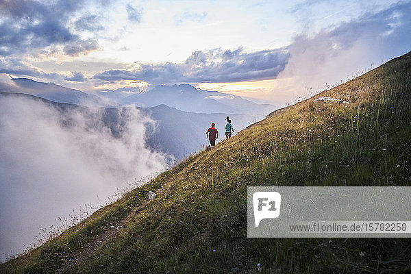 Man and woman running uphill in the mountains