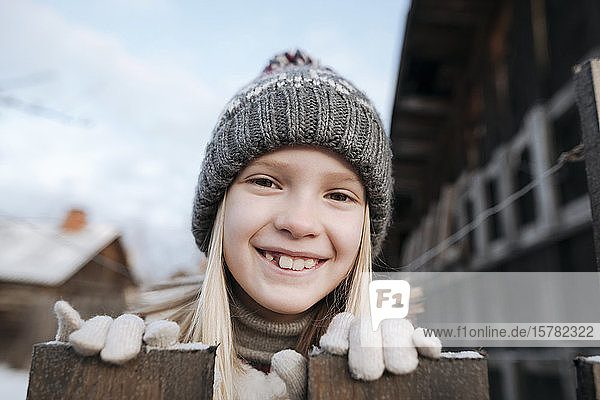 Porträt eines glücklichen Mädchens mit Wollmütze im Winter