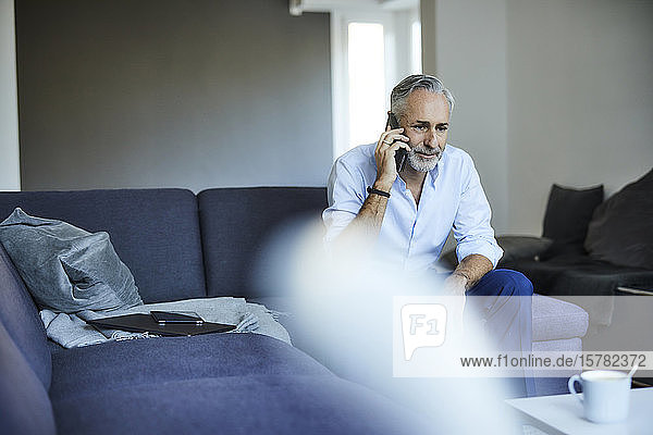 Mature man on the phone at home