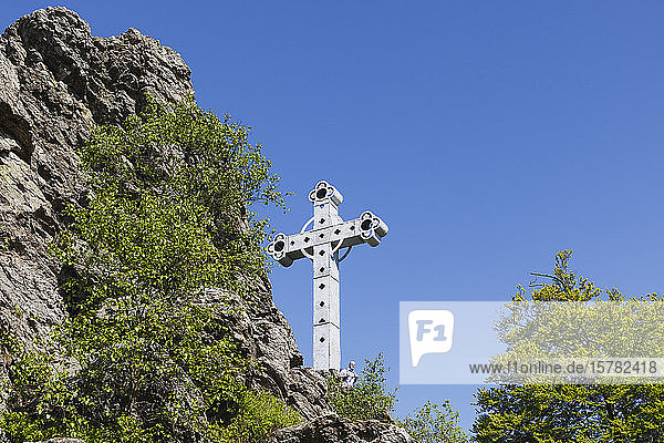 Belgium High Fens Richelsley (80m long rock) Low angle view of hiker standing at Eisenkreuz Kreuz im Venn (6m high)