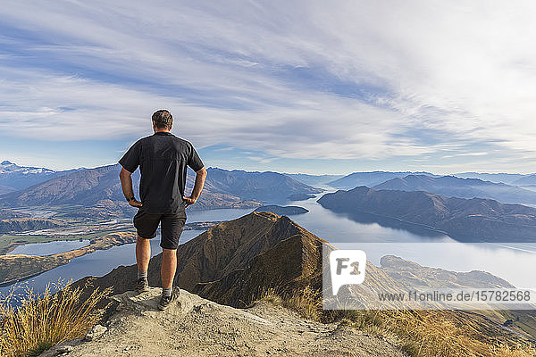 Hiker standing on viewpoint at Roys Peak  looking to Mount Aspiring  Lake Wanaka  South Island  New Zealand