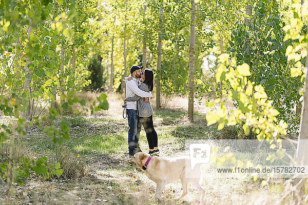 Ein Paar spielt mit seinem Hund in einem Park