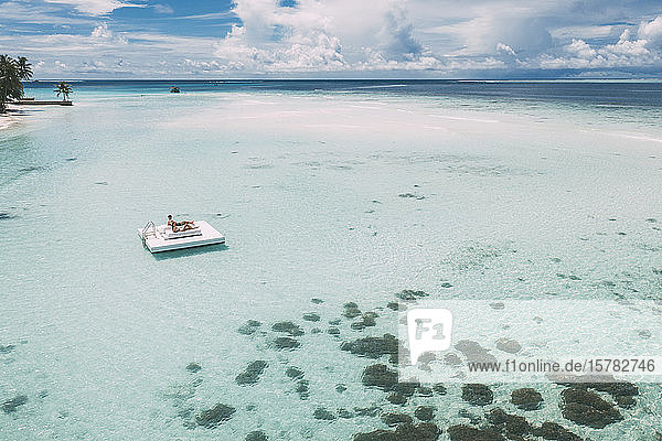 Auf einer Plattform im Meer liegendes Ehepaar  Insel Maguhdhuvaa  Gaafu-Dhaalu-Atoll  Malediven
