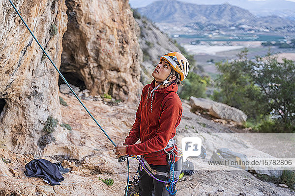 Female climber preparing looking up rock face