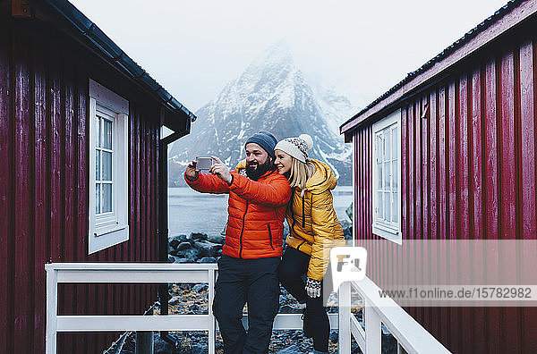 Touristenpaar beim Selfie auf einer Veranda auf Hamnoy  Lofoten  Norwegen