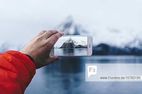 Nahaufnahme eines Touristen bei der Aufnahme eines Smartphone-Fotos auf Hamnoy Lofoten Norwegen