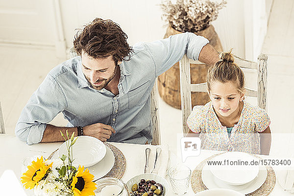 Vater und Tochter sitzen am Esstisch