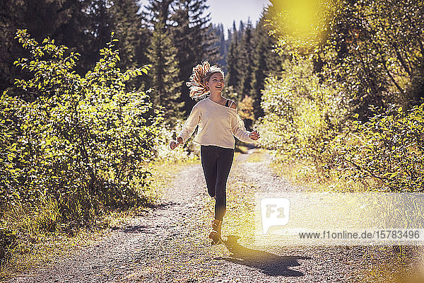 Girl running and jumping on a forest path  having fun