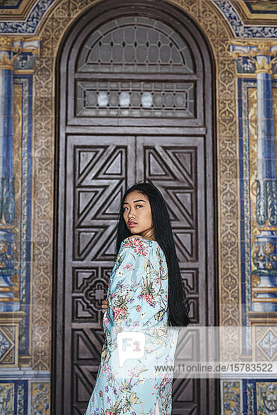 Porträt einer schönen jungen Frau in einem Kimono vor einer Tür