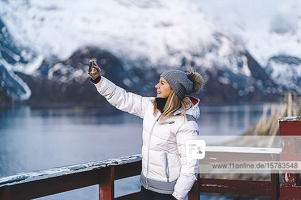 Happy tourist taking a selfie at Hamnoy  Lofoten  Norway