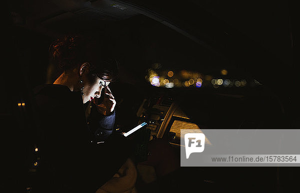 Junge Frau benutzt nachts ein Smartphone