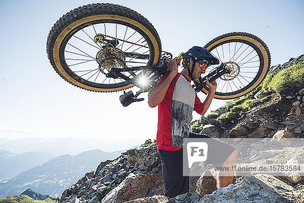 Mountainbiker carrying his mountainbike