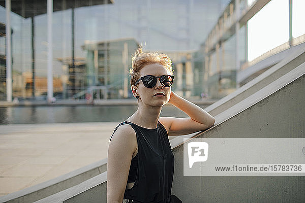 Elegante rothaarige Frau mit Sonnenbrille in der Stadt  Porträt