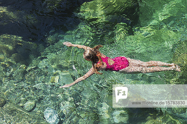Woman swimming in refreshing Verszasca river