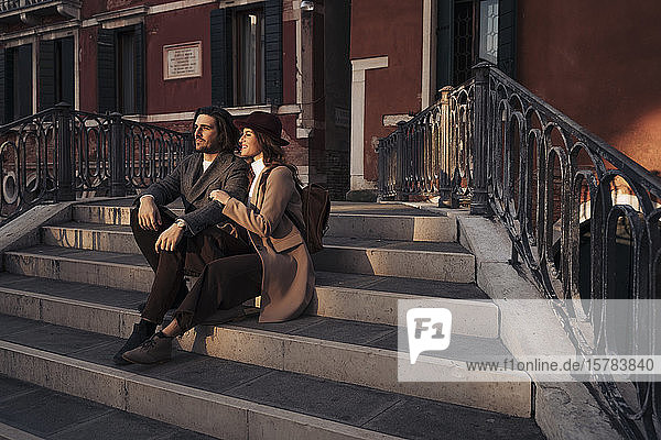 Junges Paar sitzt auf einer Brücke in der Stadt Venedig  Italien