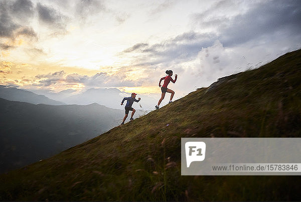 Man and woman running uphill in the mountains