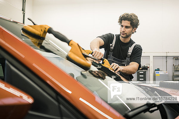 Automechaniker in einer Werkstatt beim Fensterwechsel