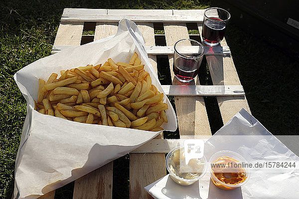 Frankreich  Bretagne  Audierne  Pommes Frites mit Mayonnaise  Ketchup und Rotwein - Picknick auf Holzkiste