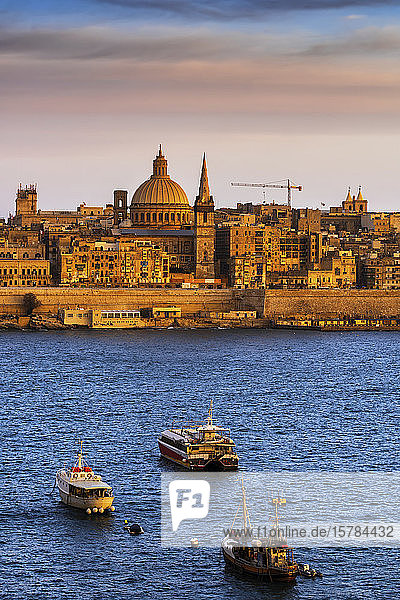 Malta Valletta Stadtsilhouette bei Sonnenuntergang Boote im Hafen von Marsamxett im Vordergrund