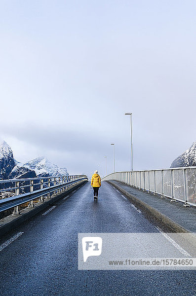Tourist überquert eine Brücke bei Hamnoy  Lofoten  Norwegen