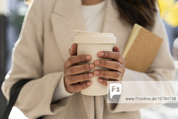 Close-up of woman holding takeaway coffee