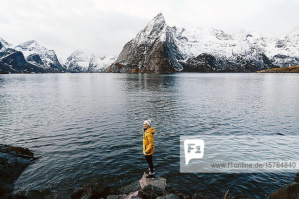 Glücklicher Tourist steht auf einem Felsen in Hamnoy  Lofoten  Norwegen