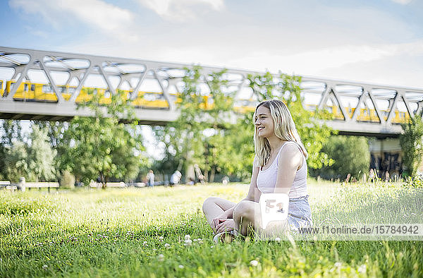 Smiling young woman relaxing on a meadow in summer  Berlin  Germany
