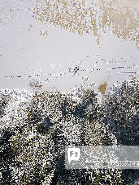Russia Leningrad Oblast Tikhvin Aerial view of two men fishing on frozen shore