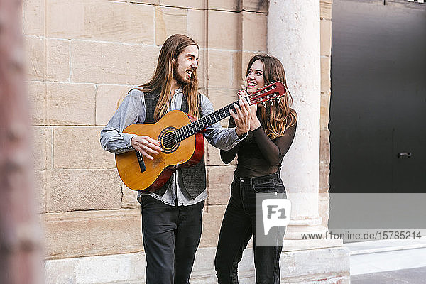 Portrait of two happy young musicians in the city