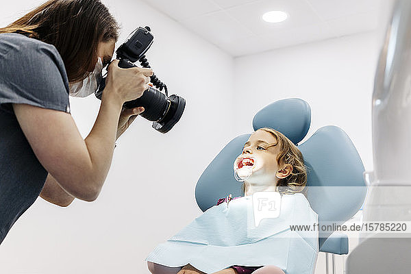 Zahnarzt fotografiert Mädchen in Zahnbehandlung