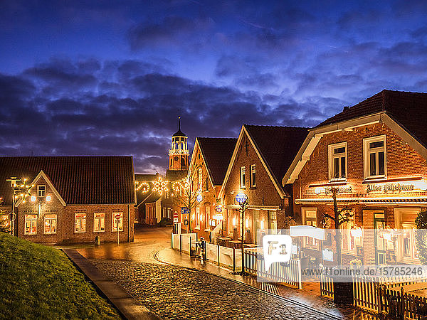 Deutschland  Niedersachsen  Landkreis Leer  Friesland  Ditzum  Weihnachtlich beleuchtete Häuser in der Abenddämmerung