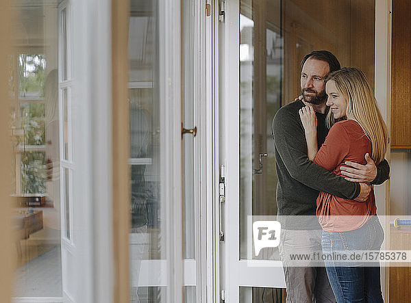 Glückliches Paar umarmt sich in ihrem gemütlichen Heim