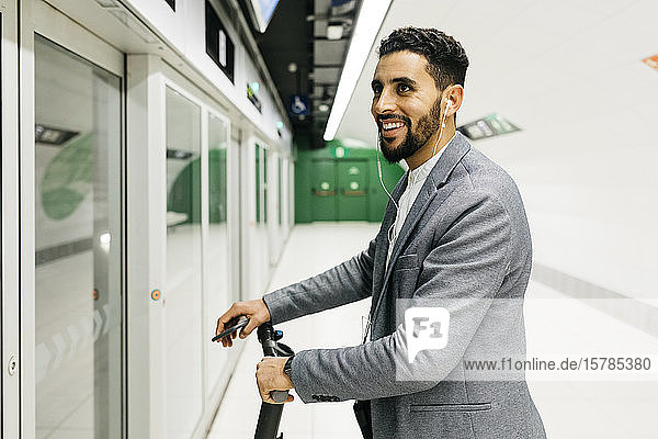 Young businessman with electric scooter in subway station