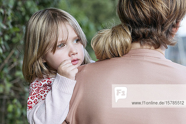 Portrait of little girl on mother's arms
