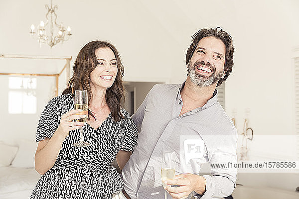 Glückliches Paar trinkt Champagner im Ferienhaus